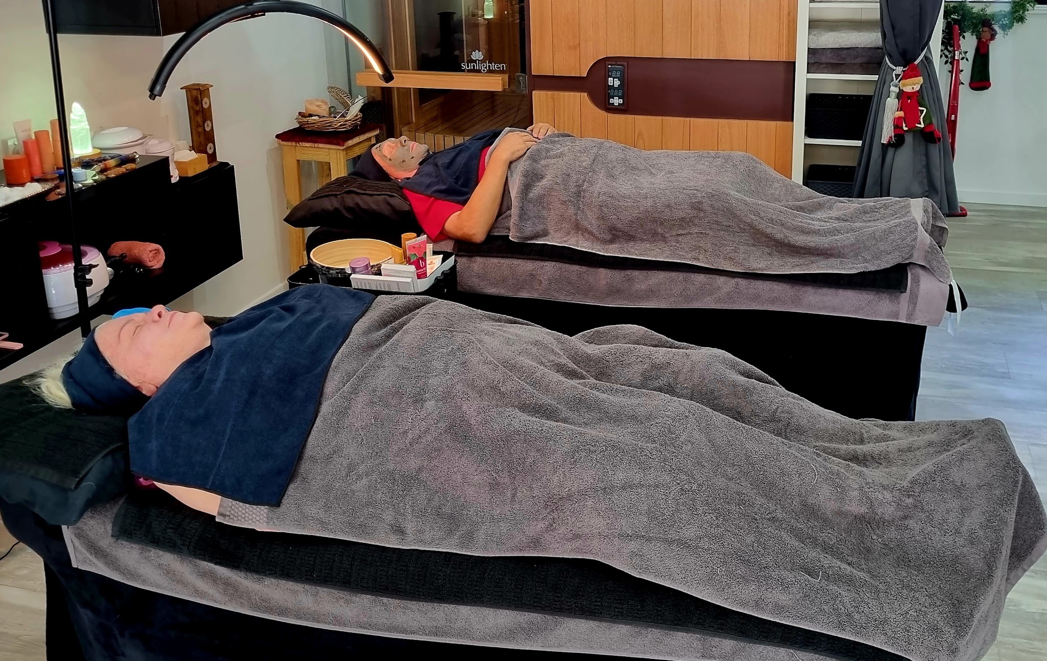 Two clients resting under warm blankets during a treatment in the studio